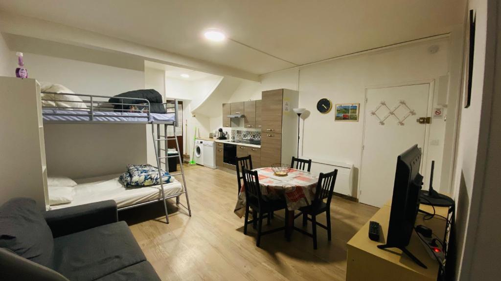 - un salon avec une table et des lits superposés dans l'établissement résidence les pâquerettes N 1, à Le Mont-Dore