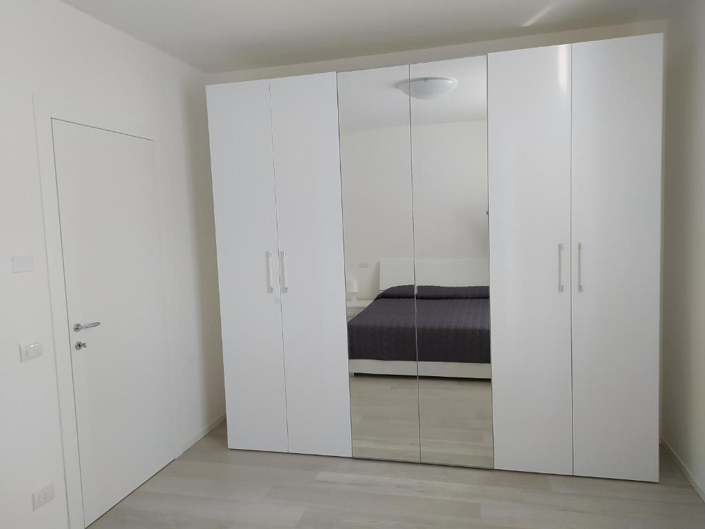 a bedroom with white cabinets and a bed at Jesolo Appartamenti F2 - Black and White in Lido di Jesolo
