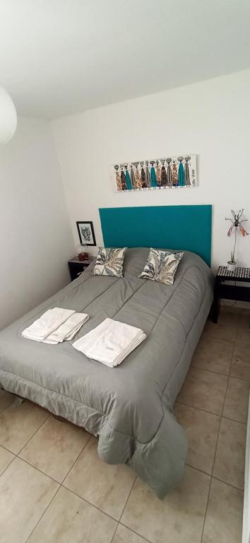 Cama grande en habitación con pared azul y blanca en La Plata moderno apart, en La Plata