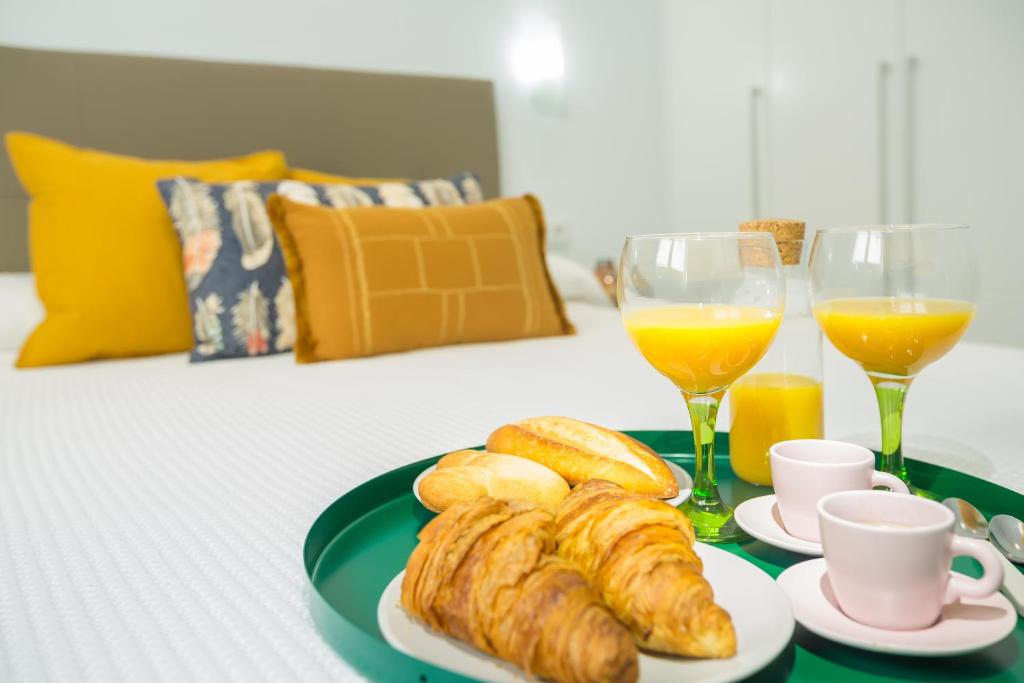 una mesa con un plato de cruasanes y dos vasos de zumo de naranja en Hercot Canteras Beach,Sun,City WIFI free, en Las Palmas de Gran Canaria