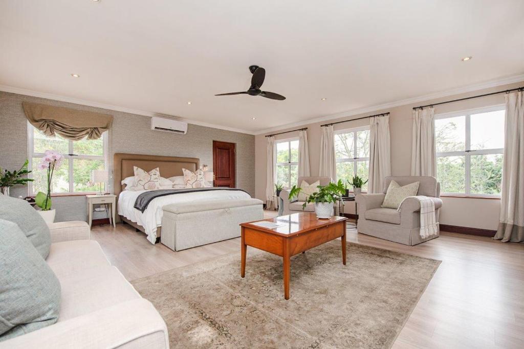 a bedroom with a bed and a living room at Wild Olive Executive Suite in Johannesburg