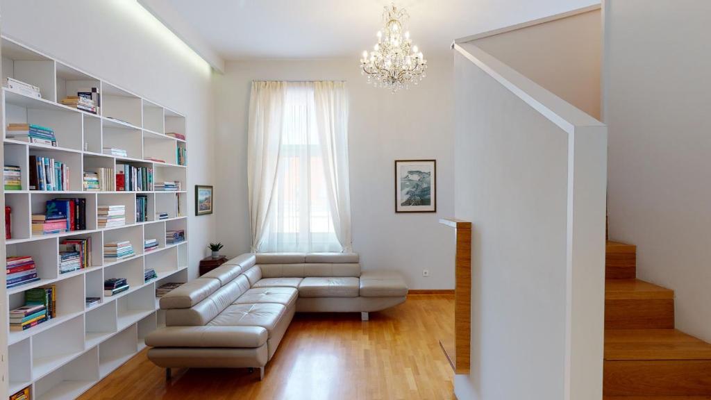 a living room with a couch and book shelves at La Dolce Vita Zagreb, Centrally located & Spacious in Zagreb