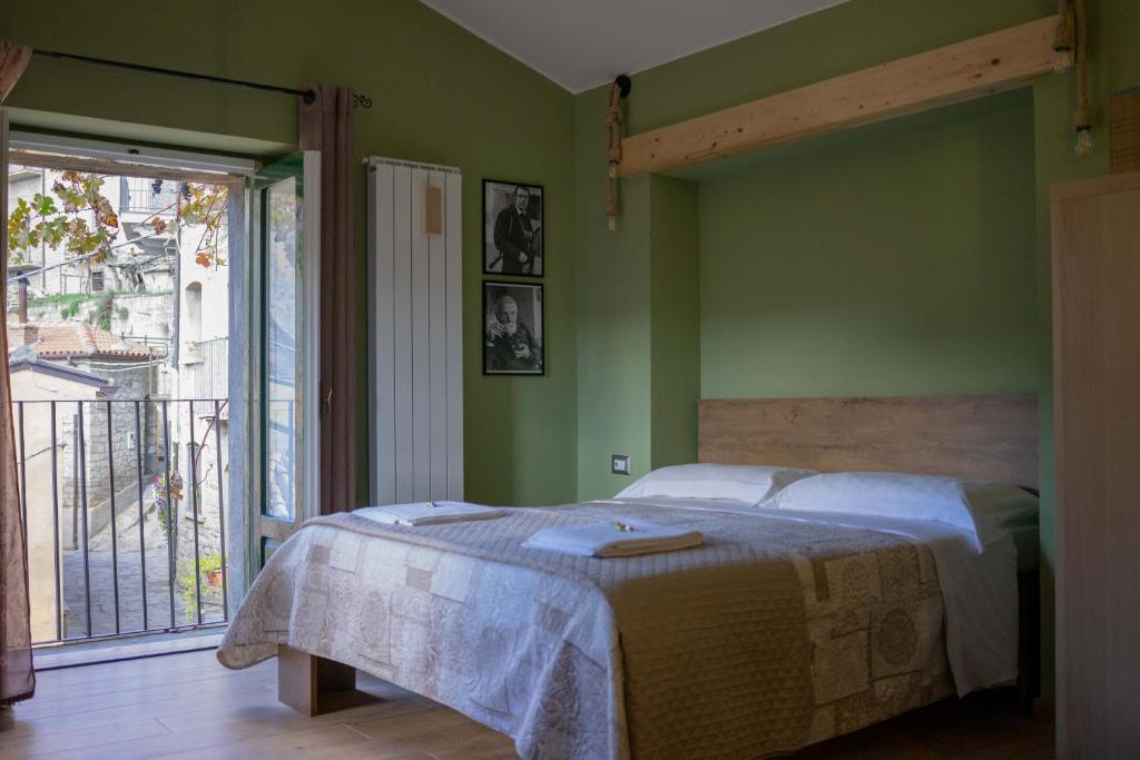 1 dormitorio con cama y ventana grande en B&B Sud e Magia, en Castelmezzano