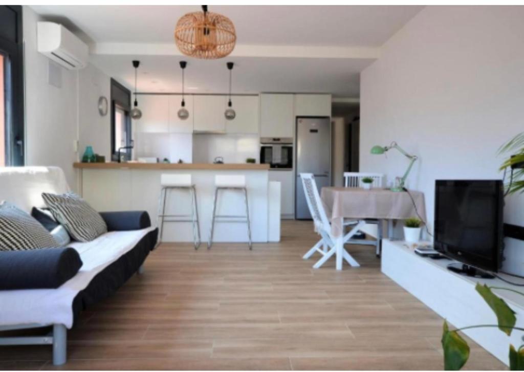 a living room with a couch and a kitchen at BRAND NEW & BEST LOCATION!!! SPOTLESS APARTMENT in Sant Feliu de Guixols