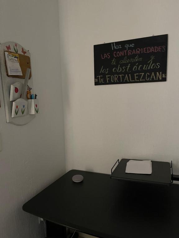 un escritorio en una habitación con un cartel en la pared en Amplio y cómodo al Sur de Zapopan, en Guadalajara