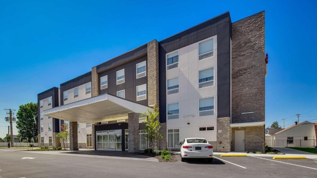 an office building with a car parked in a parking lot at Best Western Plus Hershey in Hershey