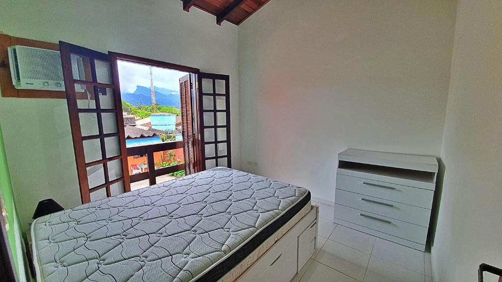 Schlafzimmer mit einem Bett und einem Fenster in der Unterkunft Kitnet Superior com Vista para o Mar in São Sebastião