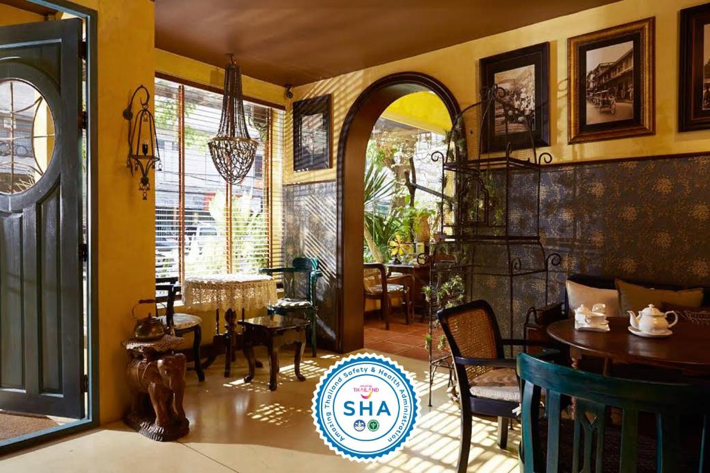 a living room filled with furniture and a large window at Old Capital Bike Inn - SHA Certified in Bangkok