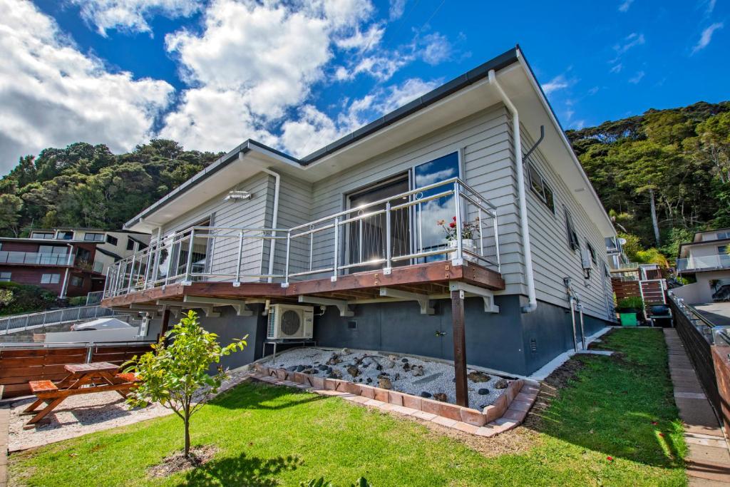 a house with a balcony and a yard at Paihia Paradise - Paihia Holiday Home in Paihia