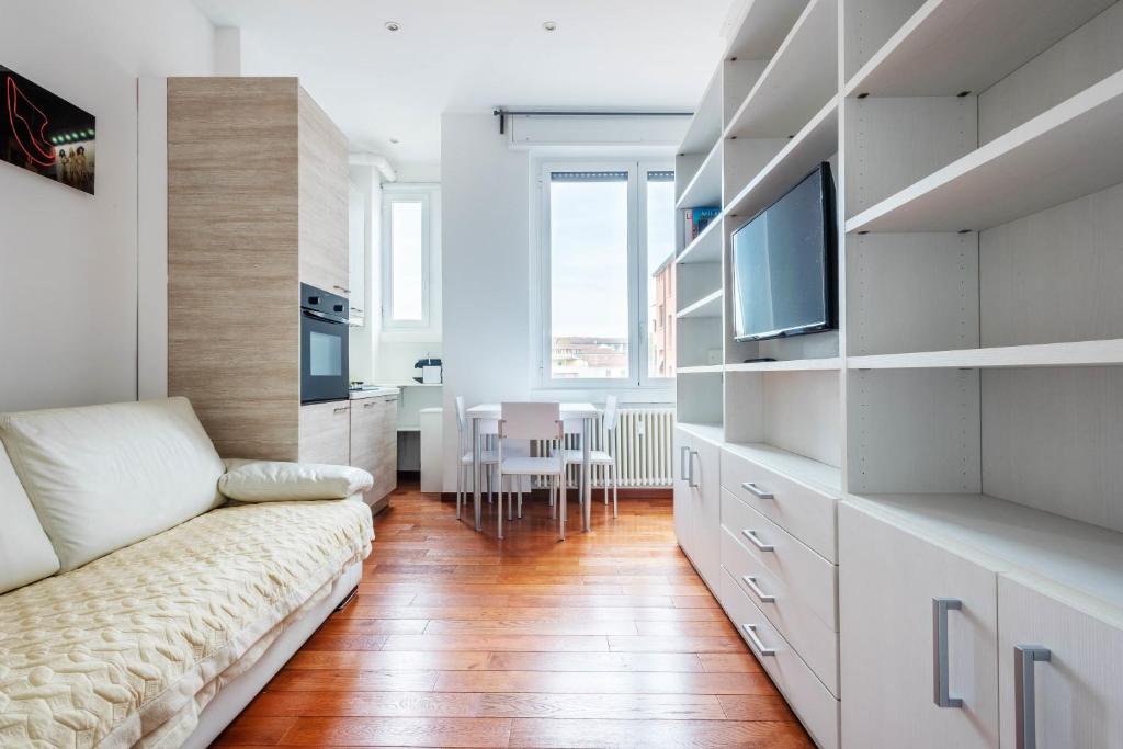 ein Wohnzimmer mit einem Sofa und einem TV in der Unterkunft Nice and Cozy studio in Porta Romana by Easylife in Mailand