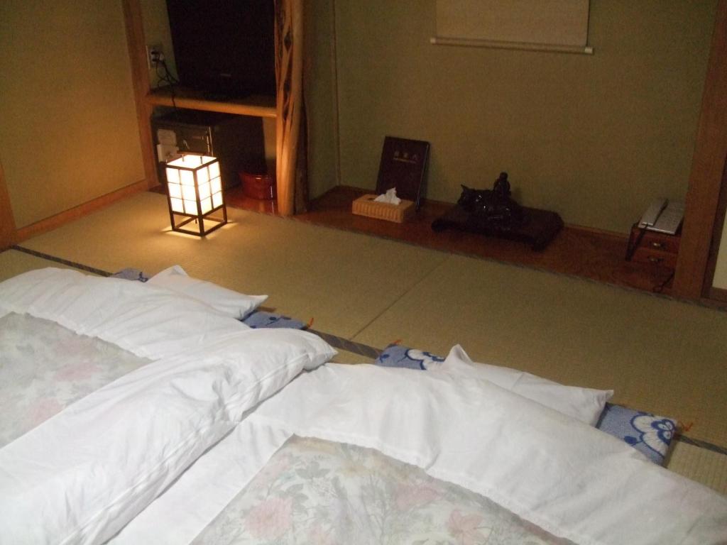 Postel nebo postele na pokoji v ubytování Marunaka Ryokan
