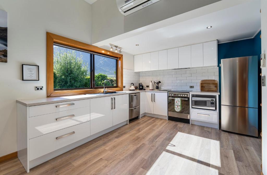 a kitchen with white cabinets and a window at Remarkables View in Queenstown