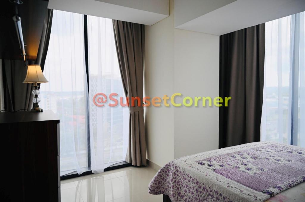 um quarto com uma cama e uma grande janela em Sunset Corner @Pollux Habibie em Batam Center