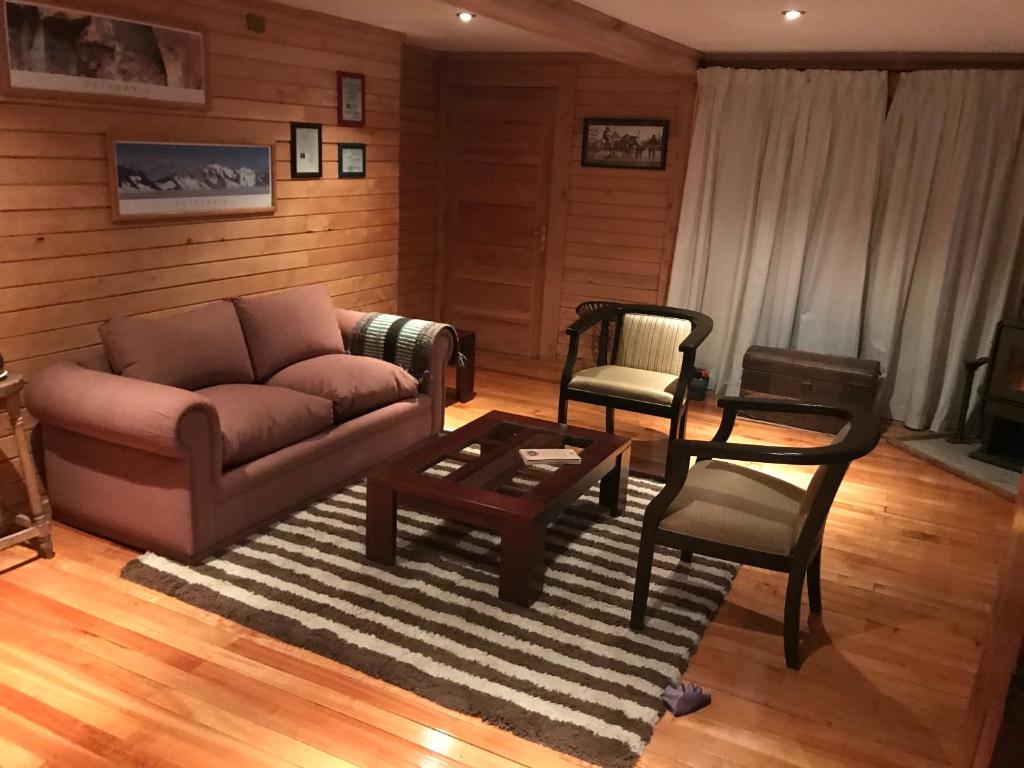 a living room with a couch and a table and chairs at Cabañas - Casa Rural 32 in Villa O'Higgins