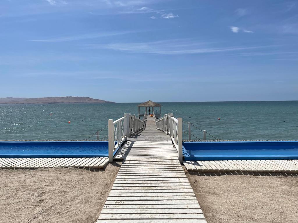 eine hölzerne Promenade, die zum Meer am Strand führt in der Unterkunft Ocean View Apartment in Paracas