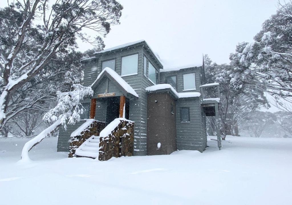 dom pokryty śniegiem z przodu w obiekcie Alpenglow w mieście Dinner Plain
