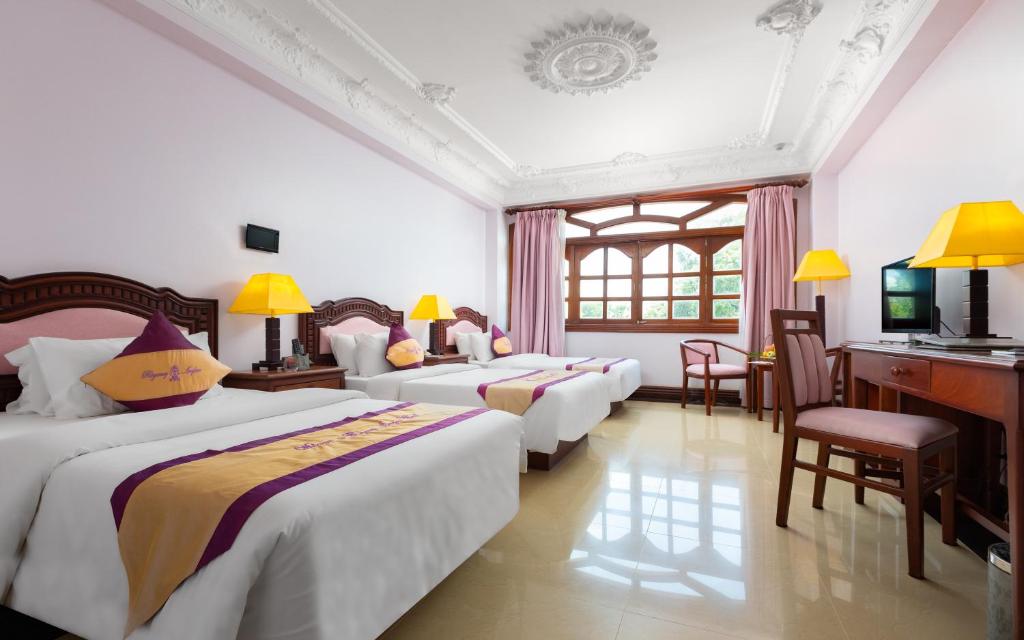 Postel nebo postele na pokoji v ubytování Regency Angkor Hotel