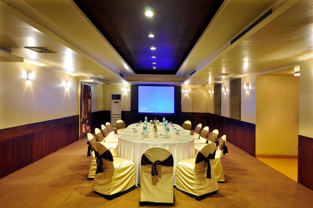 a conference room with a table and chairs and a screen at Hotel Celebration in Raipur
