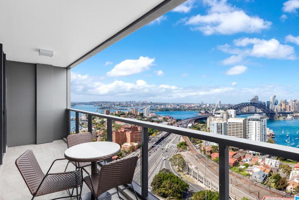 a balcony with a table and chairs and a view of the city at Meriton Suites North Sydney in Sydney