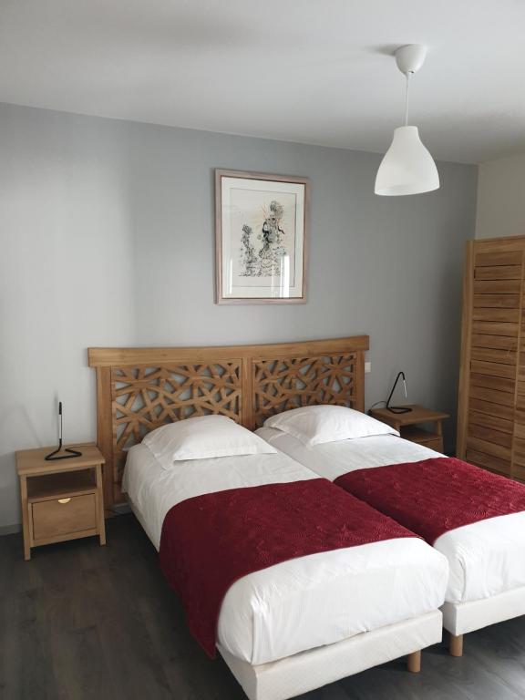 a bedroom with a large bed with a wooden headboard at Attic pour 4 personnes in Munster
