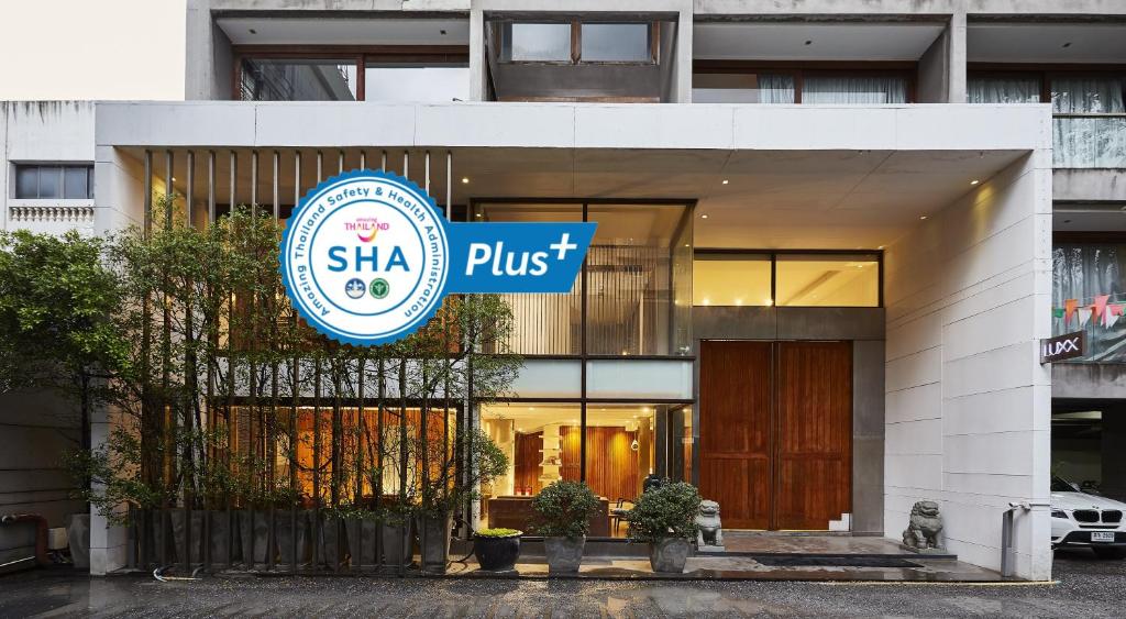 a building with a sign that reads shka plus at LUXX Langsuan Hotel - SHA Plus in Bangkok