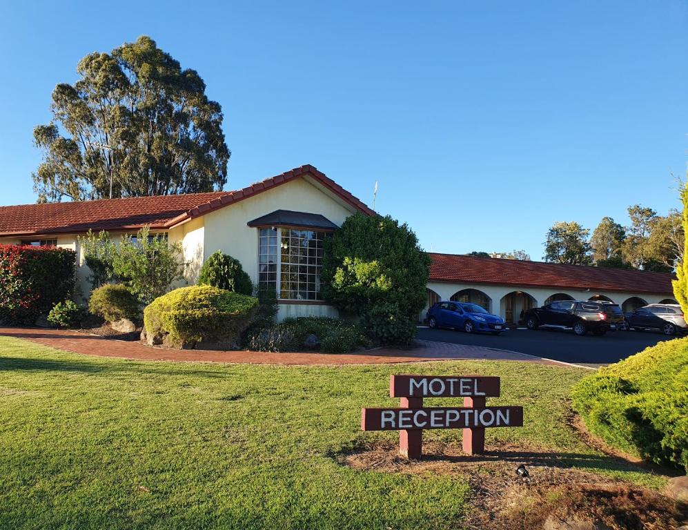 un cartello di registrazione del motel di fronte a una casa di McNevins Warwick Motel a Warwick