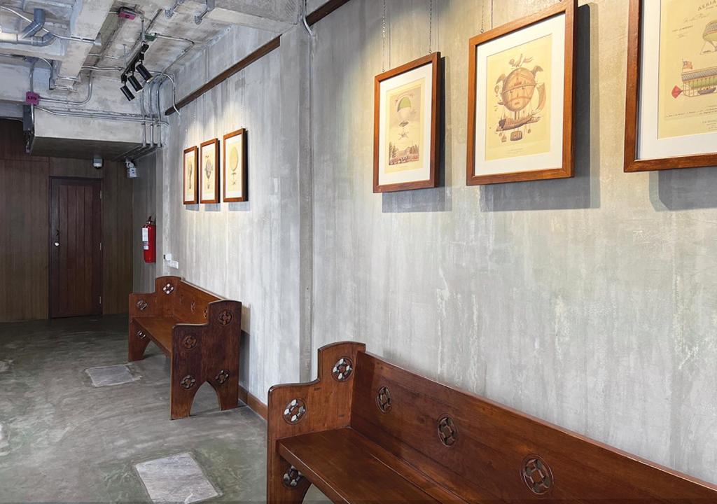 a row of benches in a room with pictures on the wall at Niagara Hotel in Bangkok