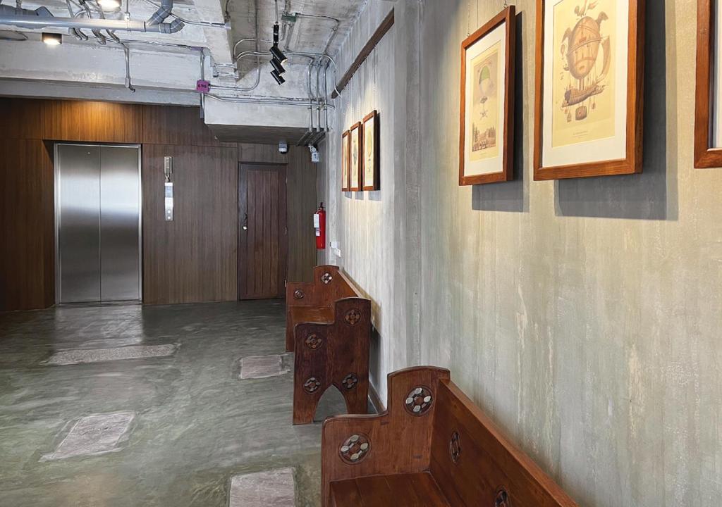 a room with a hallway with a staircase and pictures on the wall at Niagara Hotel in Bangkok