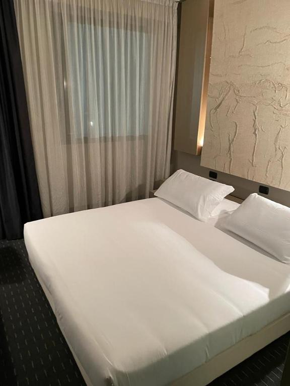 A bed or beds in a room at Bes Hotel Cremona Soncino