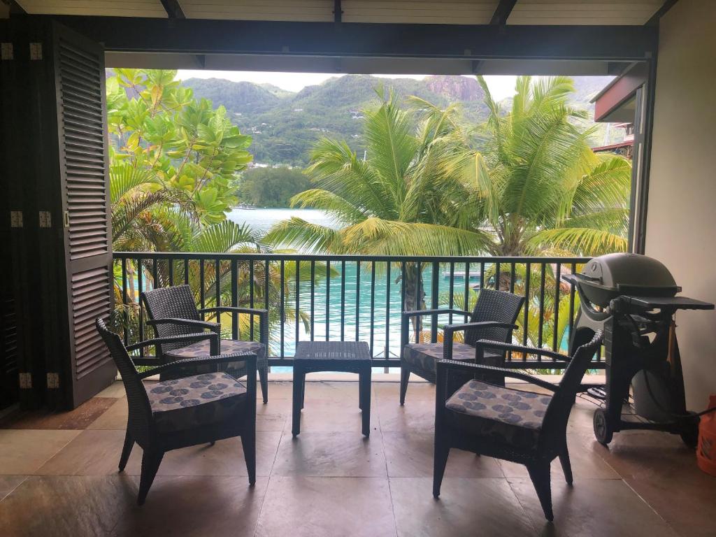 balkon z krzesłami i widokiem na wodę w obiekcie Bigarade Suite by Simply-Seychelles w mieście Eden Island
