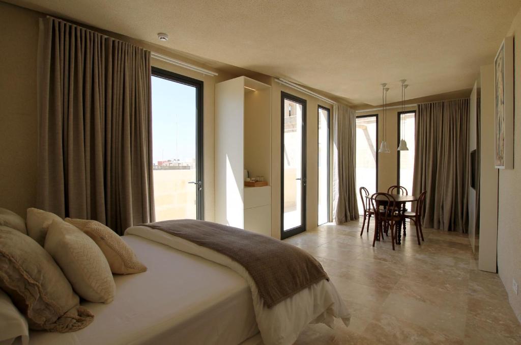 1 dormitorio con 1 cama, mesa y sillas en The King George Village Boutique Living, en Għargħur