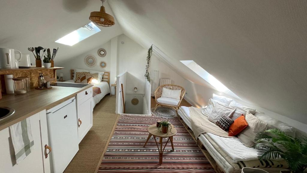 a living room with a couch and a kitchen at Le cosy marnais, centre ville, vue cathédrale in Reims