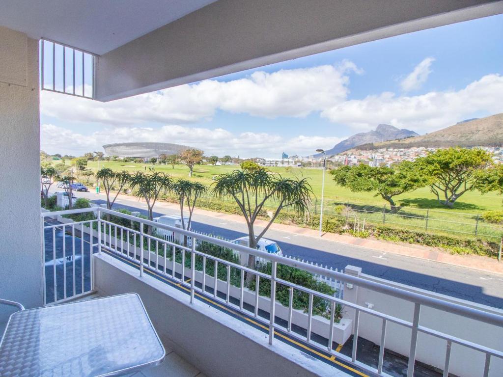 a balcony with a view of a road and palm trees at Mouille Point Apartments in Cape Town