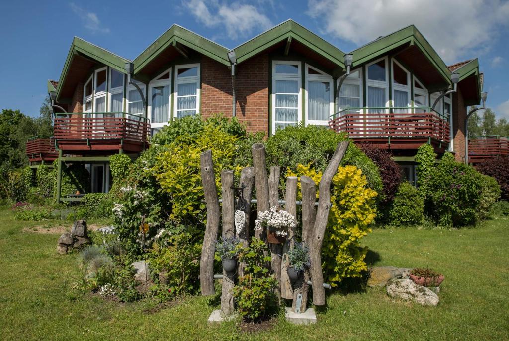 ein Haus mit einem Holzzaun davor in der Unterkunft Jana´s Ferienappartements in Plau am See