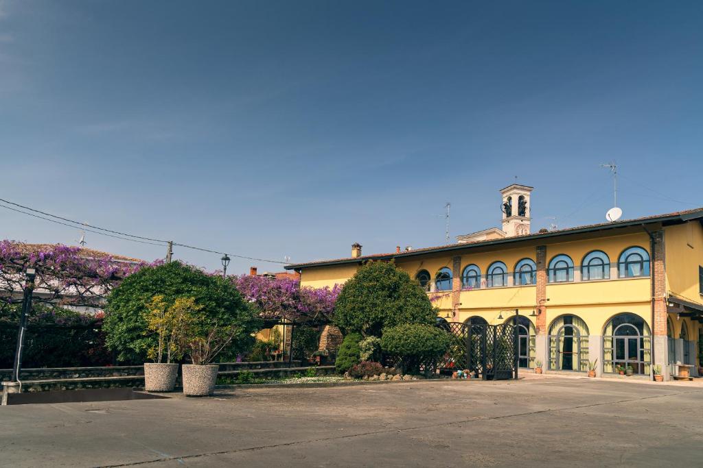 duży żółty budynek z drzewami i fioletowymi kwiatami w obiekcie il Glicine B&B RISTORANTE w mieście Cazzago San Martino