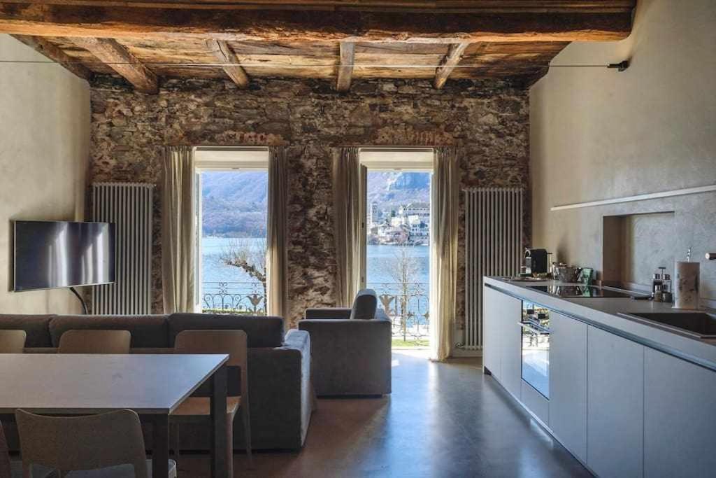 uma cozinha e sala de estar com um sofá e uma mesa em Orta Paradise 6 em Orta San Giulio