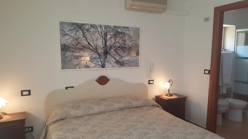 1 dormitorio con 1 cama y una pintura en la pared en Bed&Breakfast L'Oasi, en Nardò