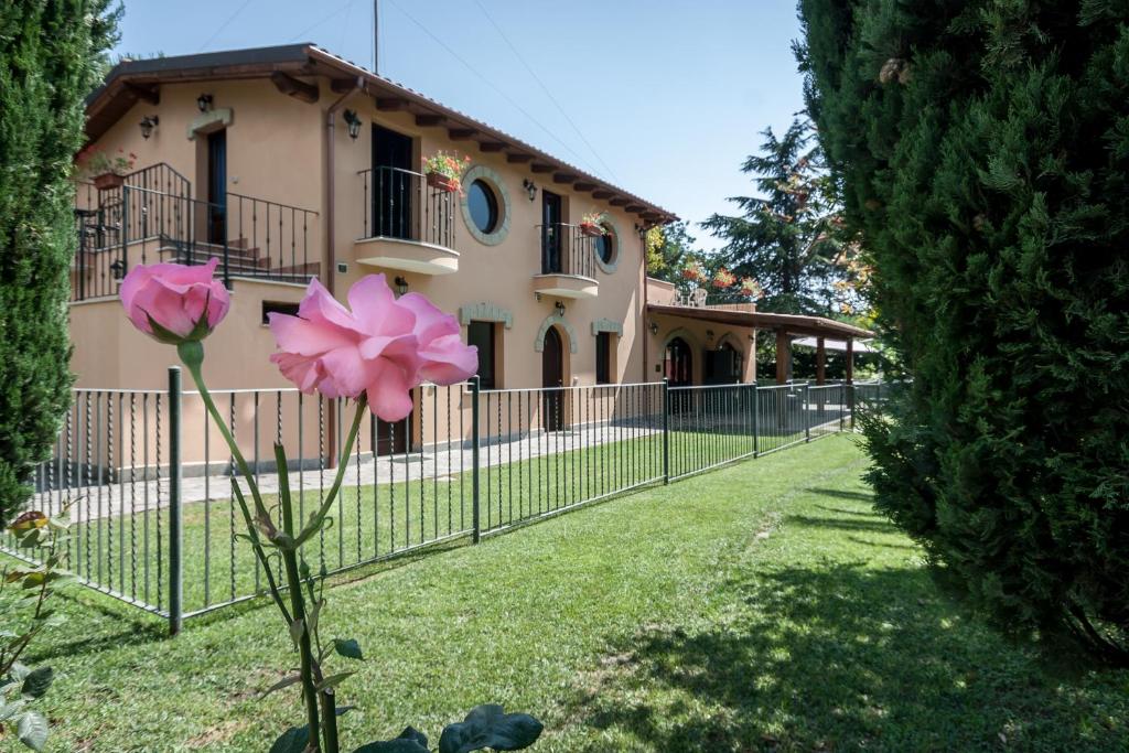 une fleur rose devant un bâtiment dans l'établissement Relais Villaggio Azzurro, à Mostacciano