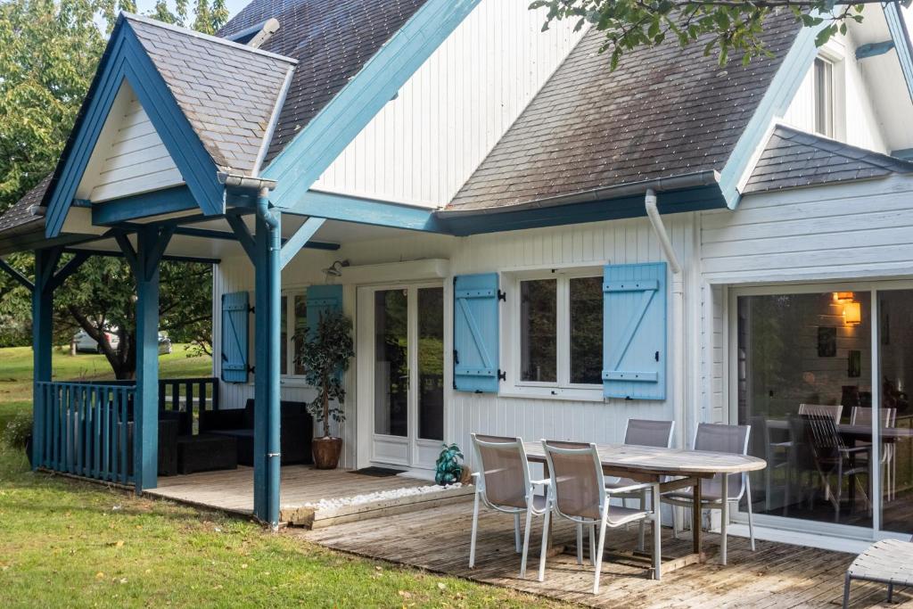 een huis met een blauw dak en een tafel en stoelen bij Le Chalet à la Mer in Erdeven