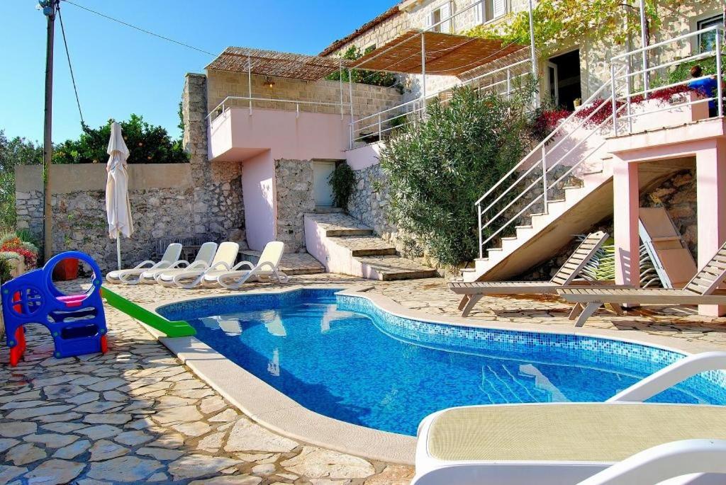 a small swimming pool with chairs and a house at Villa Tony in Orasac
