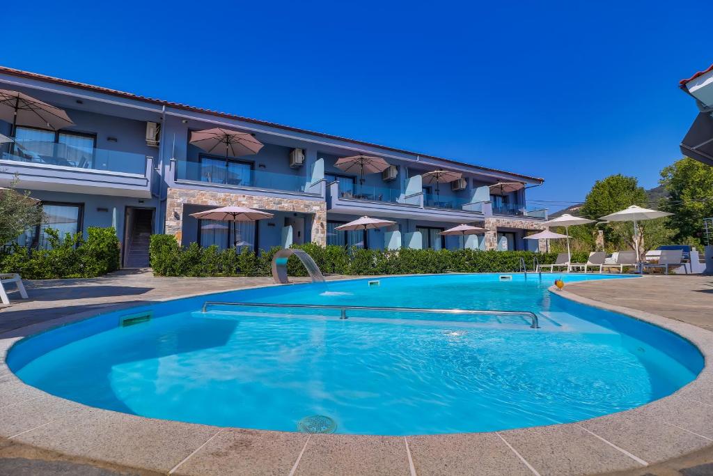 una piscina di fronte a un hotel di Theros Villas & Suites a Chrisi Ammoudia
