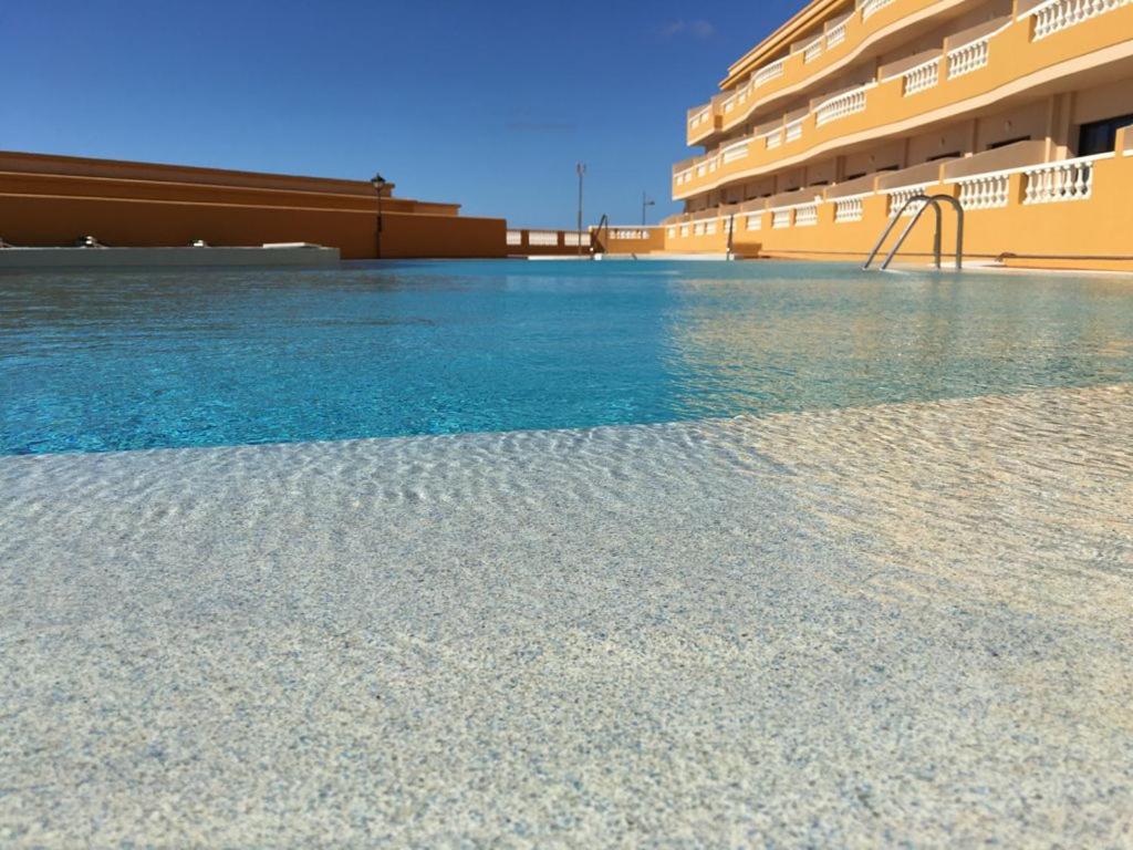 a swimming pool with a slide in front of a building at Apto Tagoro, La Restinga in La Restinga