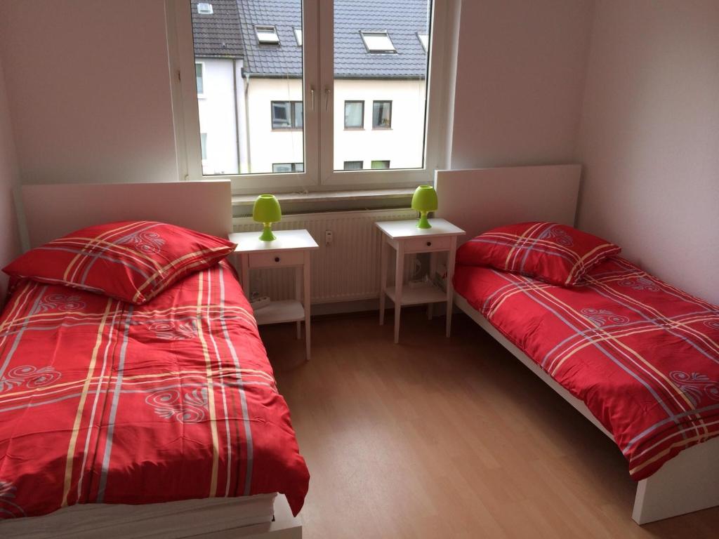 2 Betten in einem Zimmer mit Fenster in der Unterkunft White House Bochum Ehrenfeld in Bochum