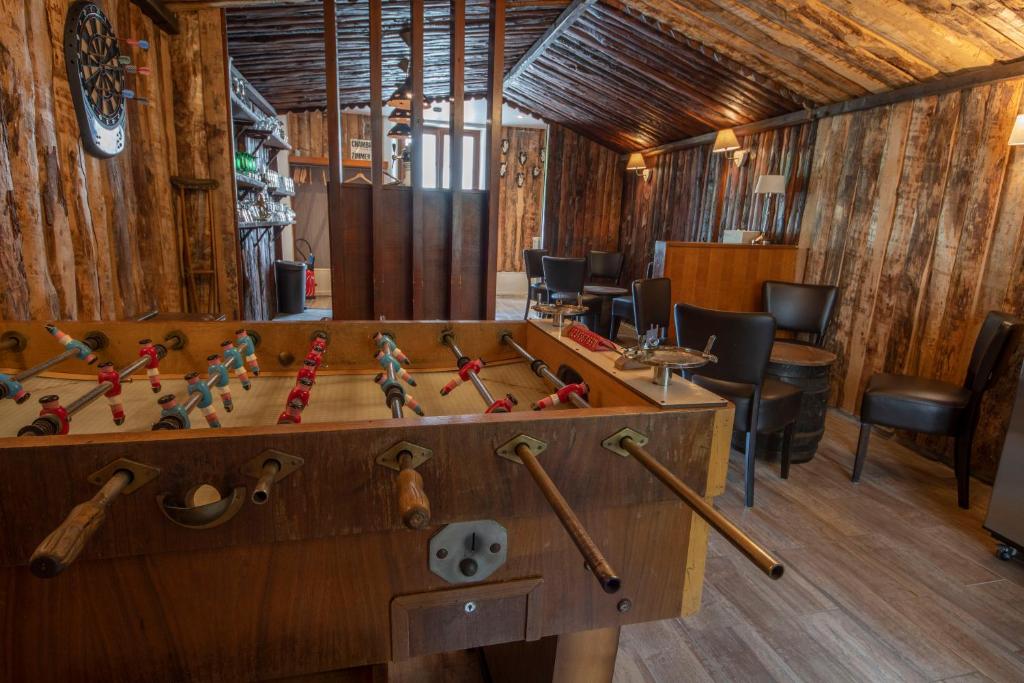 una habitación con una mesa con bates de béisbol en Les 2 Clefs en Bussang