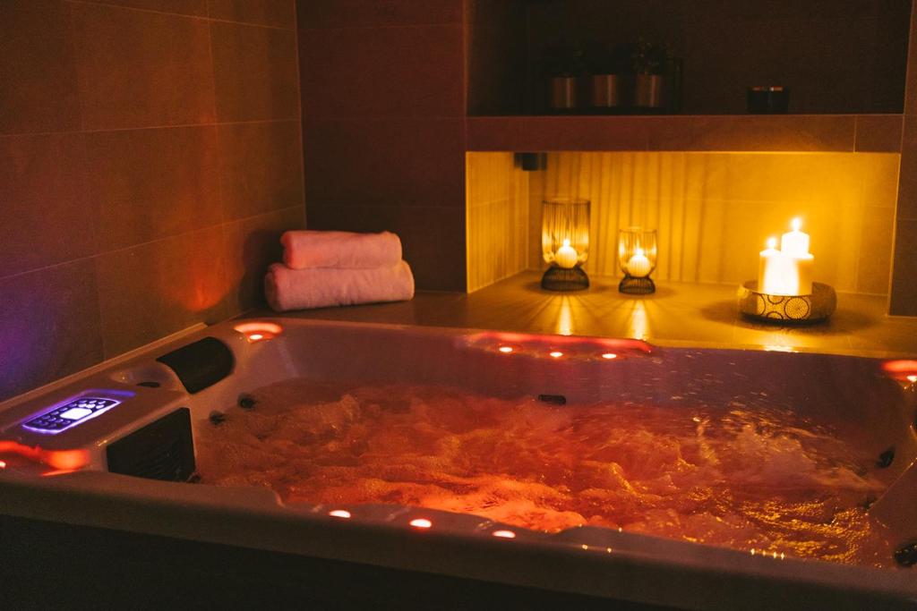 a large bath tub with a candle and two lights in it at SAVOY residence&spa in Osijek