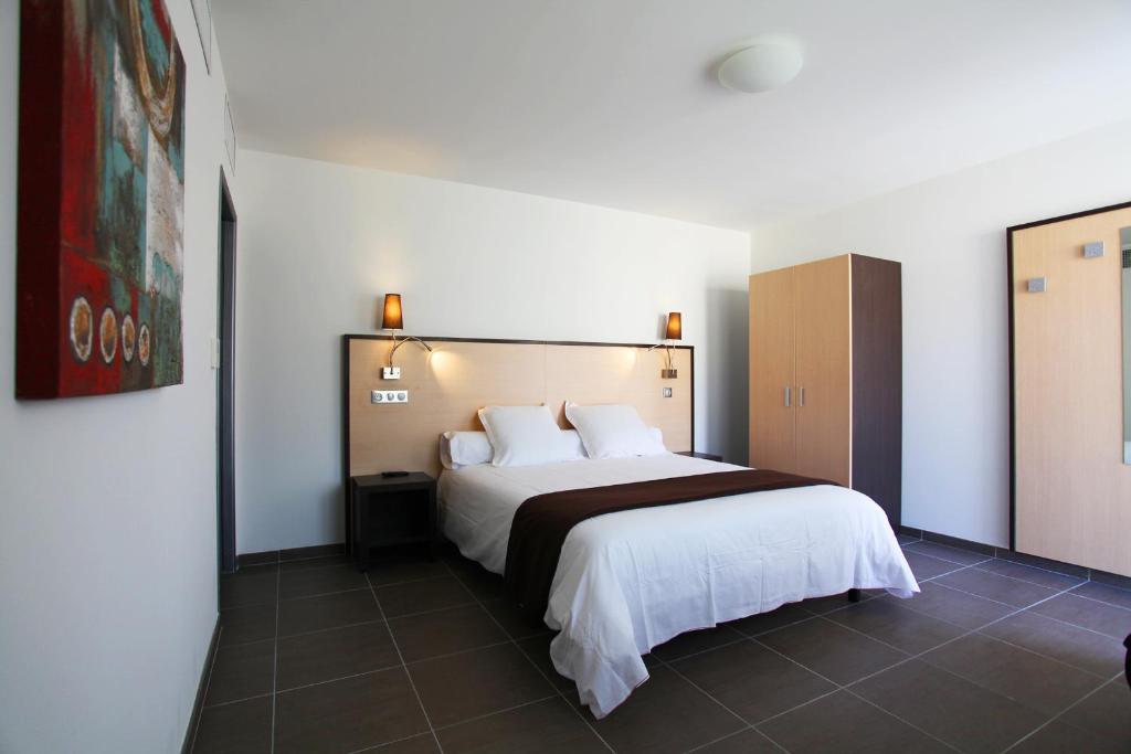 ein Schlafzimmer mit einem großen Bett in einem Zimmer in der Unterkunft Hôtel Restaurant les Pielettes in Le Rove