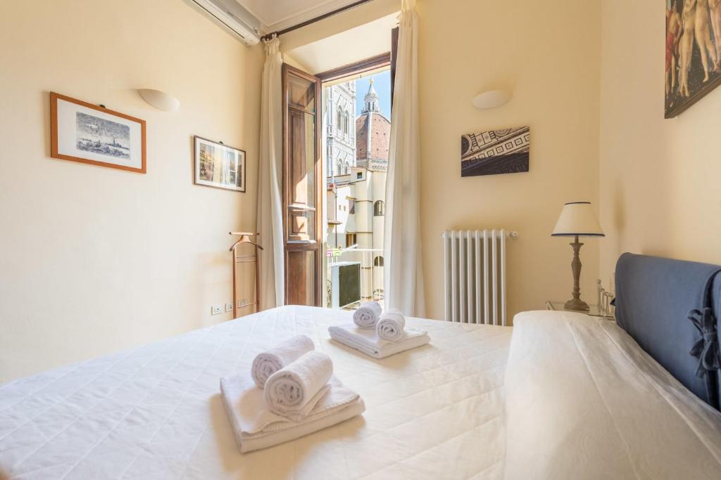 una camera da letto con un letto e asciugamani di CHARMING 2BED APARTMENT overlooking DUOMO - hosted by Sweetstay a Firenze