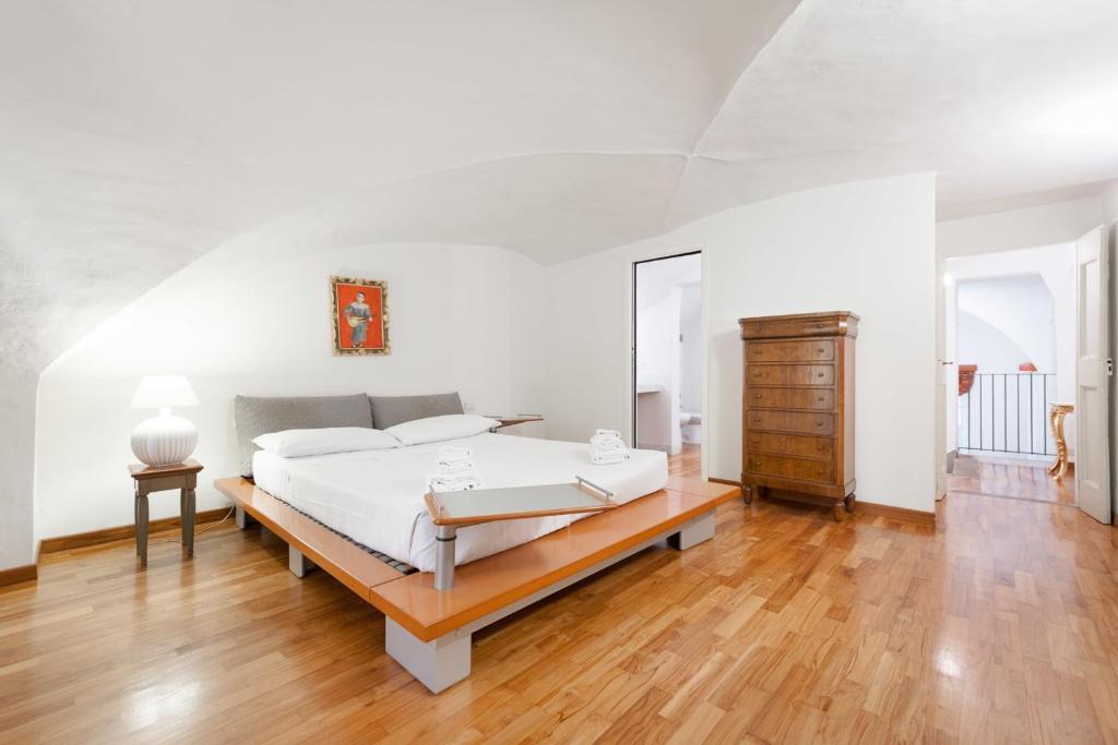 a white bedroom with a bed and a wooden floor at Pontevecchio Luxury Suite AMAZING LOCATION - hosted by Sweetstay in Florence