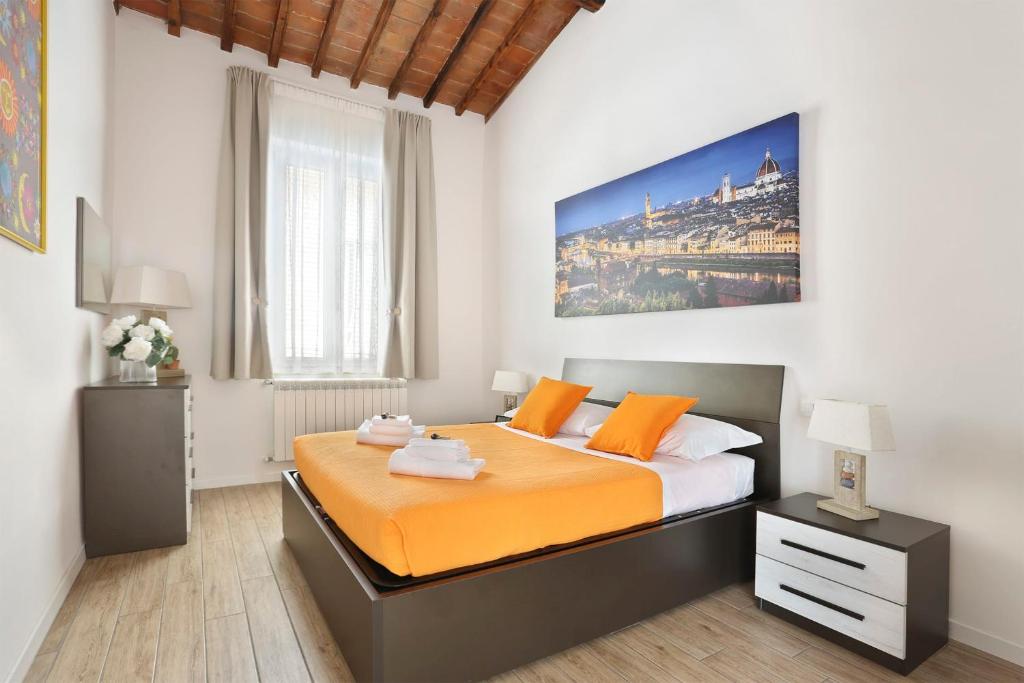 1 dormitorio con 1 cama grande con sábanas de color naranja en Granduca Apartment in Top Location, en Florencia