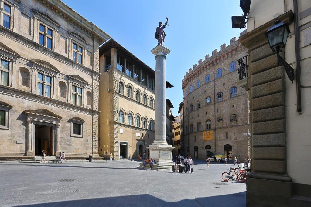 posąg na środku dziedzińca z budynkami w obiekcie Tornabuoni apartment in central Florence we Florencji